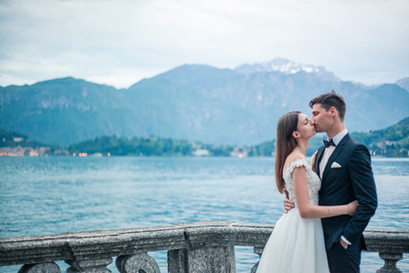wedding couple kissing on the background of the lake and the mountains in the eveningの写真素材