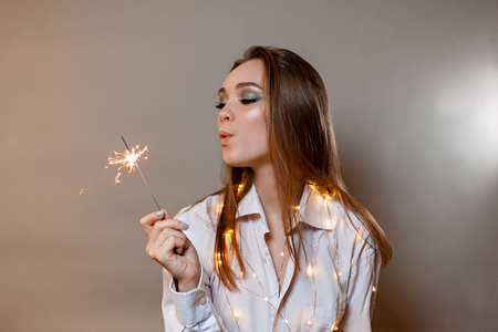 girl in shirt with smiles with sparklerの写真素材