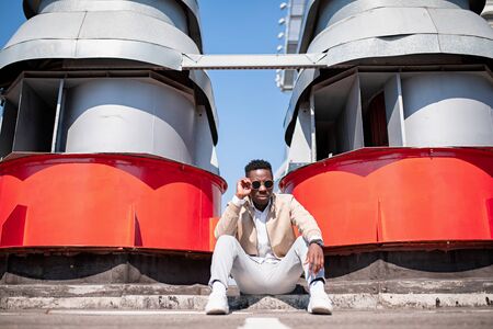 Handsome black young man in a jacket and white shirt on the street. Businessman