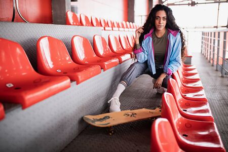 beautiful curly black girl with long hair in the stadiumの写真素材