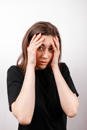 Sad brunette woman looks upset at the camera on a white background. isolatedの写真素材