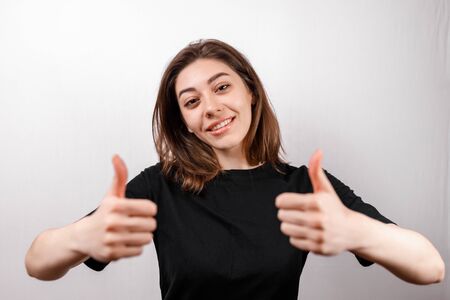young brunette woman in a black shirt on a white background. emotions. isolateの写真素材