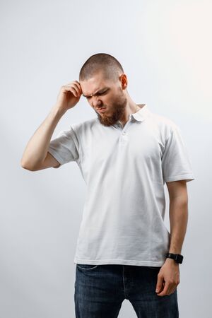 Portrait of a handsome young man looking down on a white background. isolated. place for textの写真素材