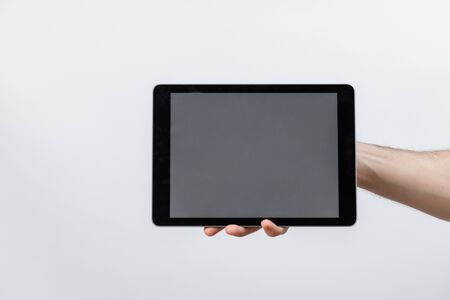 hand holds a tablet with a white screen on a white background. isolated