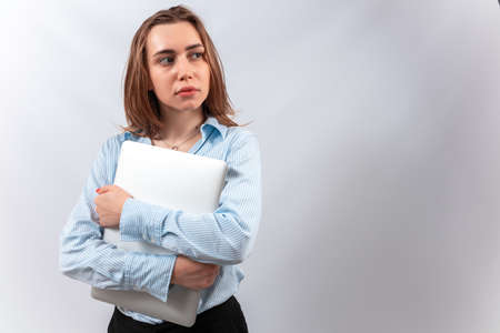 a woman in a blue blouse stands with a laptop in her hands. isolate