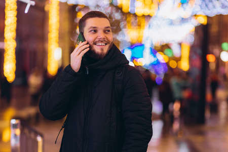 a man calls on the phone. night city. winter.の写真素材