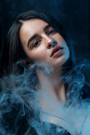 close-up portrait of a beautiful young brunette woman with professional makeup in a black jacket in...