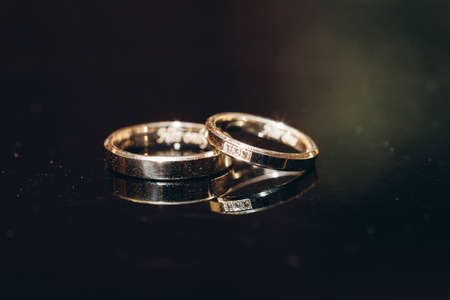 wedding rings on black tableの写真素材