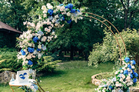 Wedding benches with guests and flower arch for ceremony outdoorsの写真素材