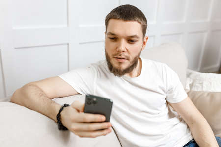 young man at home on the couch talking video call from the phone.