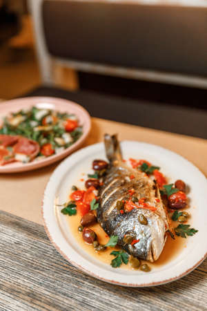 dish plate with whole fried fish in a restaurant.の写真素材
