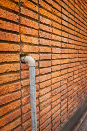 Brick wall with pipes backgroundの写真素材