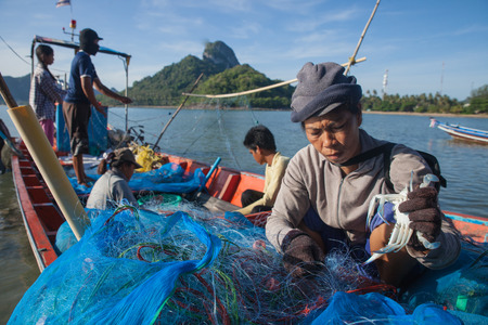SURAT THANI, THAILAND - MAY 30: Unidentify fishermen working on th boat on May 30,2015 in Donsak pier, Surat Thani, Thailand. They're unfasten crabs from the net.のeditorial素材
