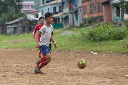 POKHARA, NEPAL - SEPT 11, 2015 : Unidentified people playing football on the ground near fewa lake on September 11, 2015 in  Pokhara, Nepal.のeditorial素材