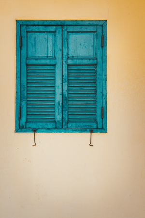 The green window with yellow wall in retro style.の写真素材