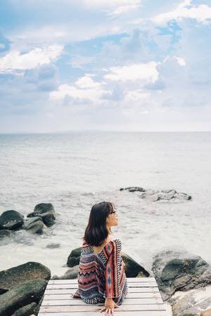 The beautiful woman sitting on the wooden  bridge near the beach in Koh munnork island, Thailand.の写真素材