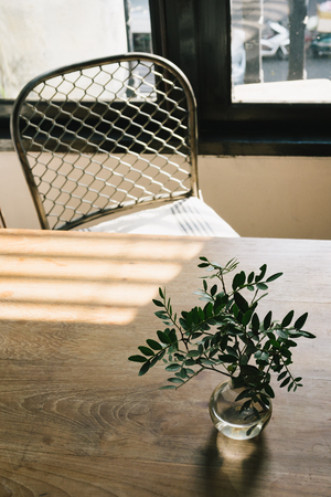 The empty coffee cafe, The wooden tables and chairs put near the window with sunlight.の写真素材