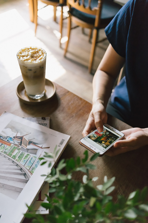 Hand of woman with smartphone in the coffee shop.