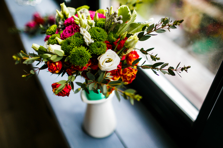 Spring bunch of flowers. Pink and red roses in a jar on the windowsillの写真素材