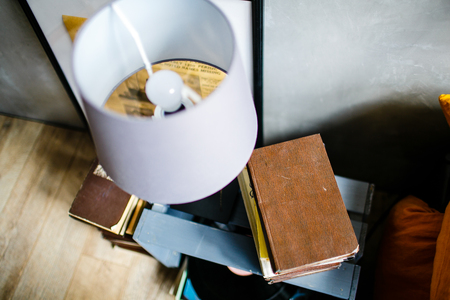 Old book and white lamp on bedside tableの写真素材