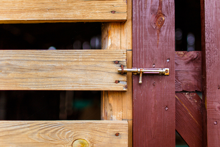 Old metal rustic latch on wooden gate close-up. Wooden gates in the rural areaの写真素材