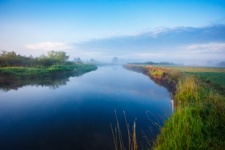 Narrow river under blue sky landscape. Summer sceneryの写真素材