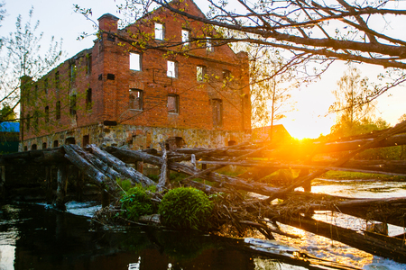 Red brick building near small village. Bright sun on horizonの写真素材