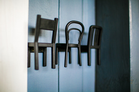 Stylish black metal coat hangers on the wooden wall close-upの写真素材