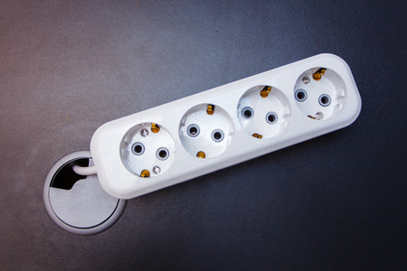 White extension cord on dark surface top viewの写真素材
