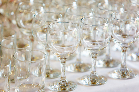 Empty wine glasses standing in row on tableの写真素材