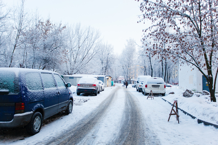 Minsk, Belarus - January 14, 2013: Tiny city road after night snowfall. Line of parked carsのeditorial素材