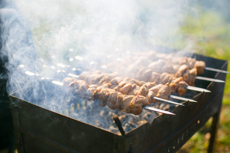 Making kebab in the open air close-up. Meat cooked on charcoalの写真素材