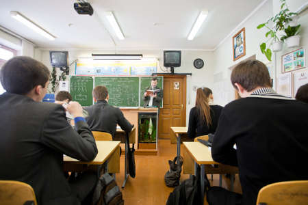 Minsk, Belarus - February 20, 2013: Professional teacher reading out loud useful information to the students at physics class at collegeのeditorial素材