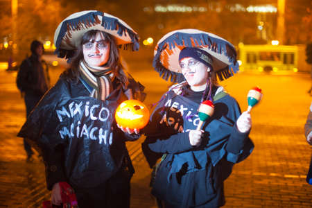 Minsk, Belarus - October 31, 2013: Two young ladies dressed in festive costumes singing and celebrating Halloween in city centerのeditorial素材