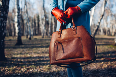 Beauty and fashion. Stylish fashionable woman wearing bright dress holding brown bag handbag.の写真素材