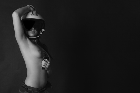The naked girl in a helmet of the fighter pilot and a pistol in a handの写真素材