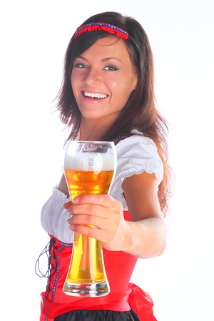 The girl in a traditional Bavarian dress with full glasses of beer in handsの写真素材