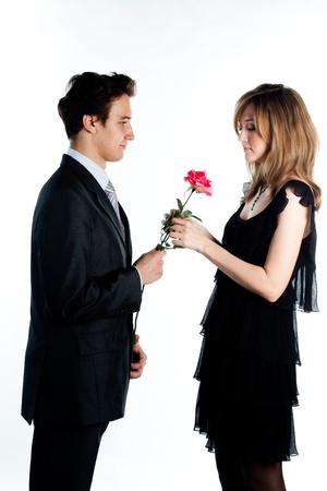 A young man gives a beautiful young woman, a flower in honor of the holidayの写真素材