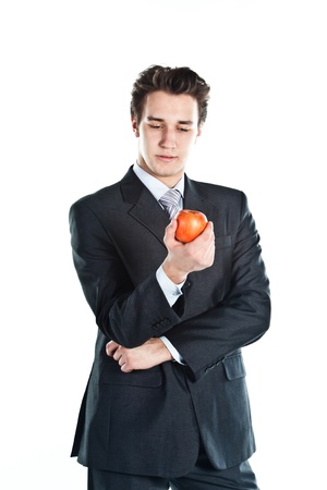 Young, successful and respected businessman in a suit with a red apple in his handの写真素材
