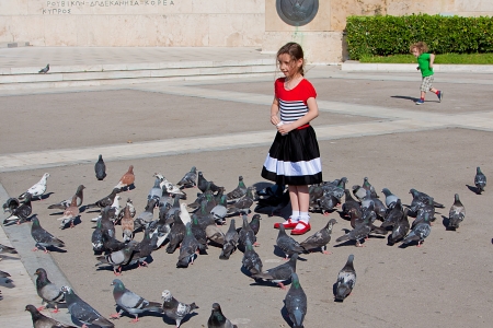 a little girl feeding a flock of pigeonsのeditorial素材