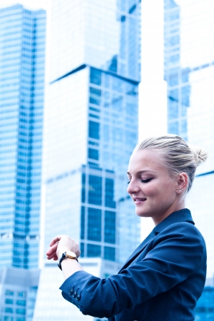 a beautiful young woman and a businessman looking at his watchの写真素材