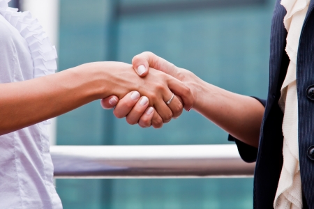Two young and beautiful business woman shaking handsの写真素材