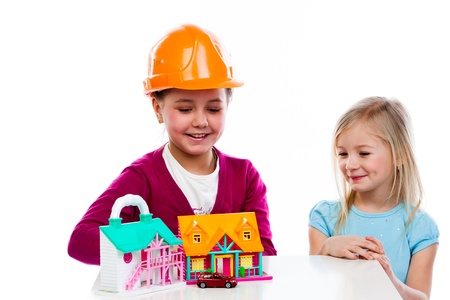 two cute little girls play with buildersの写真素材