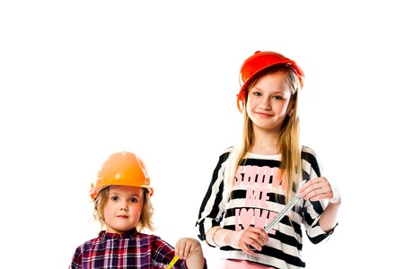 Two young beautiful girls in building helmet and tools in handの写真素材