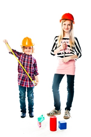 Two young beautiful girls in building helmet and tools in handの写真素材