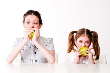 two beautiful girls with green applesの写真素材