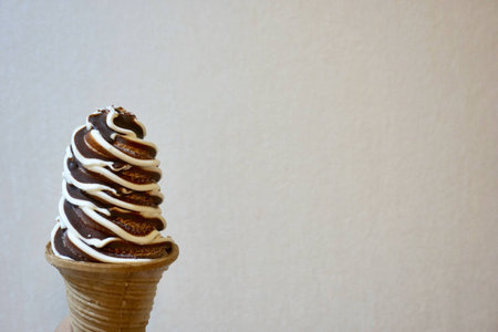 Two tone chocolate and vanilla ice cream cone on white backgroundの素材