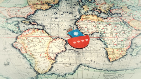 toy boat floating on the world map