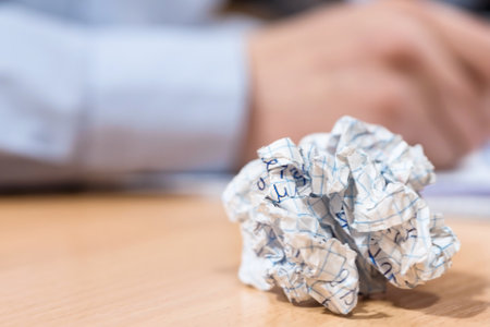 crumpled sheet of paper on a school desk on a blurred backgroundの写真素材