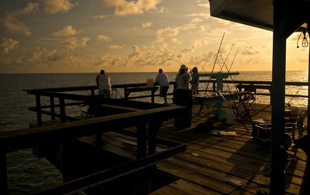 A group of people fishing in Lauderdale by the Sea Pier, in Fort Lauderdale, Florida.の写真素材